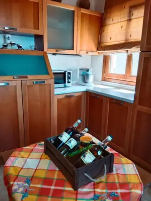 a kitchen with a table with a tray of wine bottles at Tsampika's Traditional Stone Cottage in Siana in Siána