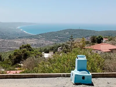 a blue toilet sitting on the side of a road at Tsampika's Traditional Stone Cottage in Siana in Siána