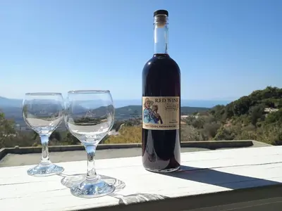a bottle of wine and two wine glasses on a table at Tsampika's Traditional Stone Cottage in Siana in Siána