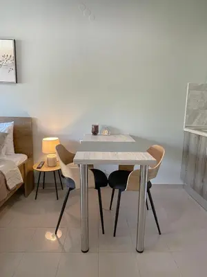 a table and chairs in a room with a couch at Rhodes Central: King Bed Studio in Rhodes Town