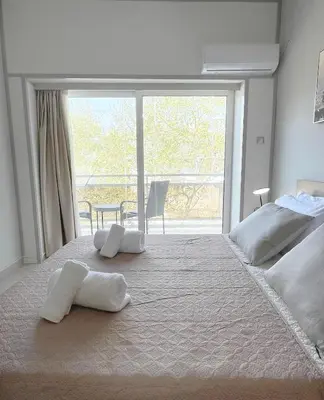 a bedroom with a large bed with two white towels on it at Rhodes Central: King Bed Studio in Rhodes Town