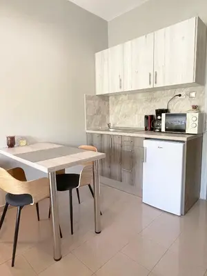 a kitchen with a table and chairs and a refrigerator at Rhodes Central: King Bed Studio in Rhodes Town