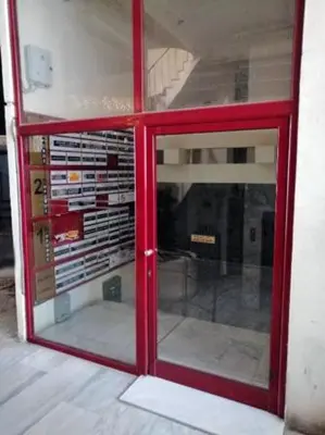 a red glass door in a building with a window at Rhodes Central: King Bed Studio in Rhodes Town