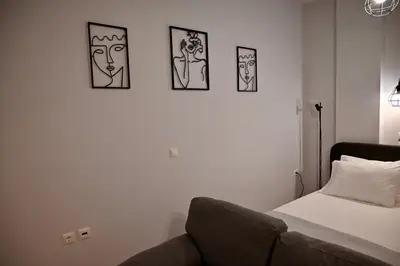 a bedroom with a bed and four pictures on the wall at Casa Sym Faliraki in Faliraki