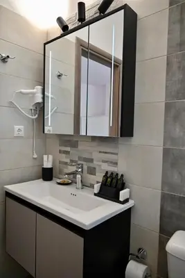 a bathroom with a sink and a mirror at Casa Sym Faliraki in Faliraki