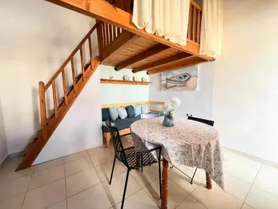 a dining room with a table and a couch at Ambela House Soroni in Soroni