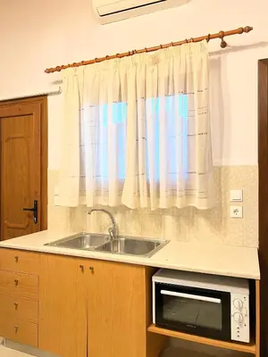 a kitchen with a sink and a microwave at Ambela House Soroni in Soroni