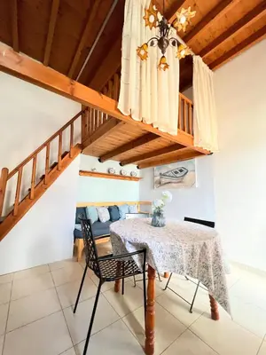 a dining room with a table and a couch at Ambela House Soroni in Soroni