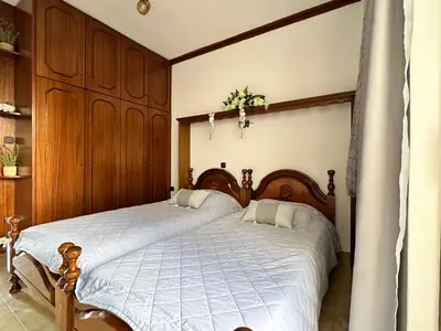 two beds in a bedroom with wooden cabinets at Sunset apartment in Rhodes Town