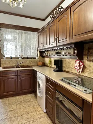 a kitchen with wooden cabinets and a white dishwasher at Sunset apartment in Rhodes Town