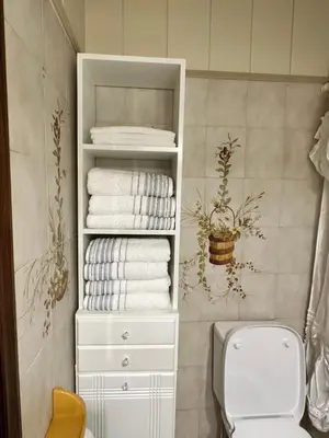 a bathroom with a white cabinet with towels and a toilet at Sunset apartment in Rhodes Town