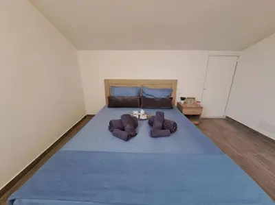 a bedroom with a large blue bed with two chairs at Lydia's cozy house in Paradeísion