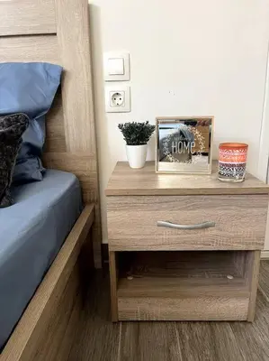 a bedroom with a bed and a wooden nightstand with a nightstand at Lydia's cozy house in Paradeísion