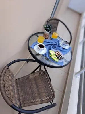 a table with two chairs and two cups of orange juice at Lydia's cozy house in Paradeísion