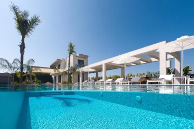 a swimming pool in front of a resort at Villa Korali in Pastida