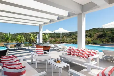 a patio with white furniture and a swimming pool at Villa Korali in Pastida