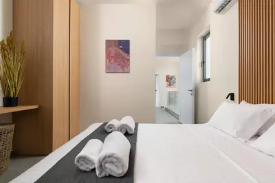 a bedroom with a white bed with towels on it at Villa Korali in Pastida