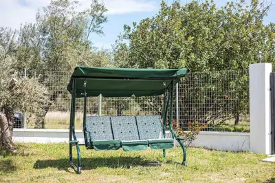 a green picnic shelter sitting in the grass at Petrino Eco Conscious Living in Kalithies