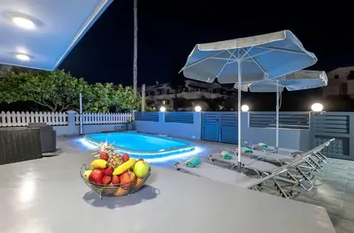 a bowl of fruit on a table next to a pool at Villa Marina in Ialyssos