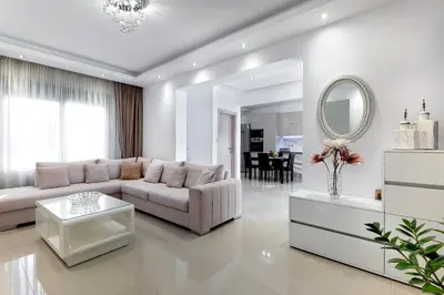 a white living room with a couch and a mirror at Villa Marina in Ialyssos