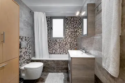 a bathroom with a toilet and a sink and a tub at Villa Marina in Ialyssos