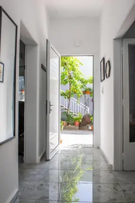 a hallway with an open door with a view of a courtyard at (Stoa escape) traditional home in Archangelos