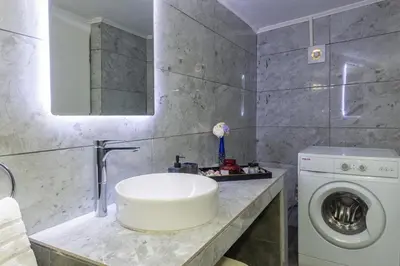 a bathroom with a sink and a washing machine at (Stoa escape) traditional home in Archangelos