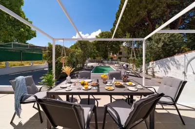 a patio with a table and chairs and a pool at Ixian Bliss Pool Villa in Ialyssos