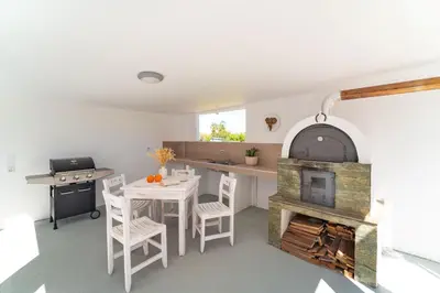a kitchen with a fireplace and a table and chairs at Ixian Bliss Pool Villa in Ialyssos