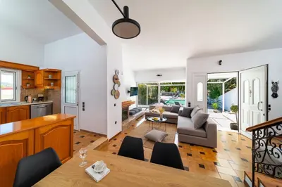 a kitchen and living room with a table and chairs at Ixian Bliss Pool Villa in Ialyssos