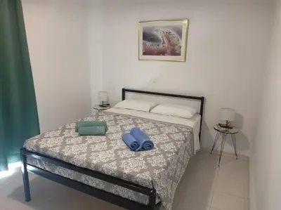 a bed with a pair of blue shoes on it at Hibiscus Green Appartments 1 in Afantou