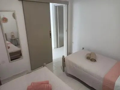 a white bedroom with a bed and a mirror at Hibiscus Green Appartments 1 in Afantou