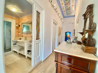 a bathroom with a sink and a vanity with a mirror at “Athenas” Neoclassic Harbour View Apartment in Symi