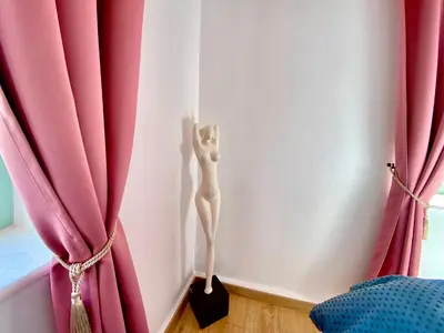 a cat standing in the corner of a room with red curtains at “Athenas” Neoclassic Harbour View Apartment in Symi