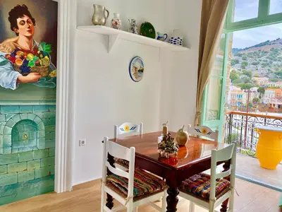 a dining room with a table and a painting on the wall at “Athenas” Neoclassic Harbour View Apartment in Symi