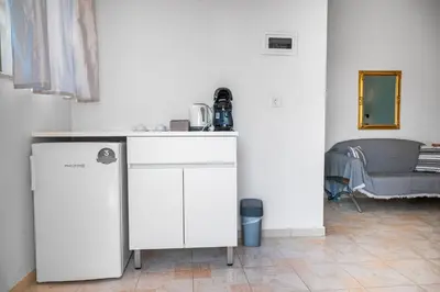 a kitchen with a counter and a chair in a room at Eva's Rooms in Faliraki