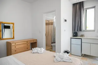 a bathroom with two towels on two beds in a room at Eva's Rooms in Faliraki