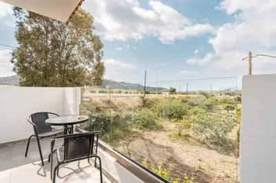 a balcony with a table and chairs and a view of the desert at Eva's Rooms in Faliraki