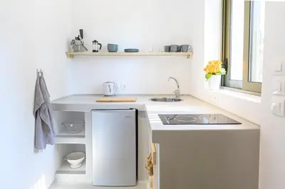 a white kitchen with a sink and a refrigerator at LOGOS Beach Village in Theologos