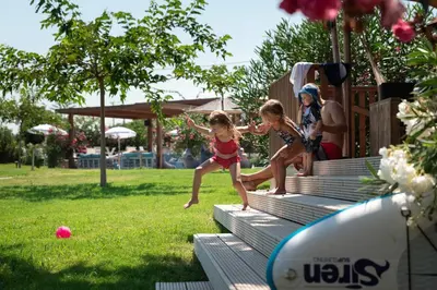 two young girls jumping on bleachers in a park at LOGOS Beach Village in Theologos
