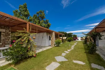 a garden with a stone pathway in front of a house at LOGOS Beach Village in Theologos