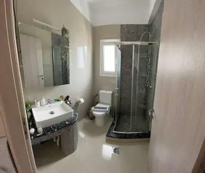 a bathroom with a sink and a shower and a toilet at The Cosy Nest -BREAKFAST INCLUDED & CAR RENTAL AVAILABLE in Rhodes Town