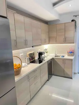 a kitchen with wooden cabinets and a basket of oranges at The Cosy Nest -BREAKFAST INCLUDED & CAR RENTAL AVAILABLE in Rhodes Town