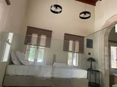 a bedroom with a white bed and some windows at Oasis Luxury House in Rhodes Town