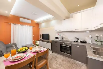 a kitchen with a table with a bowl of fruit on it at Modern Colorful House 2 rhodos in Rhodes Town