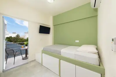 a small bedroom with a bed and a balcony at Modern Colorful House 2 rhodos in Rhodes Town