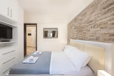 a bedroom with a bed and a brick wall at Modern Colorful House 2 rhodos in Rhodes Town
